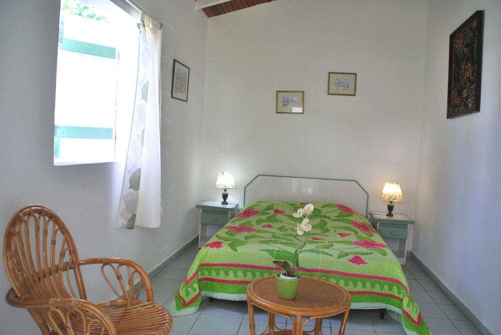 Chambre du gîte Jasmin avec sa table et sa chaise en rotin, La Bougainvillée